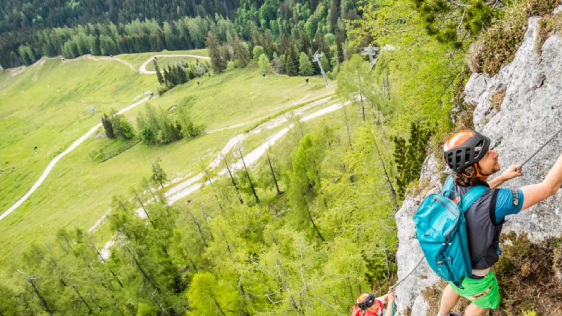 Klettersteiggeher steigen am Stahlseil der Kalkfelswand des Jenner-Klettersteigs auf.