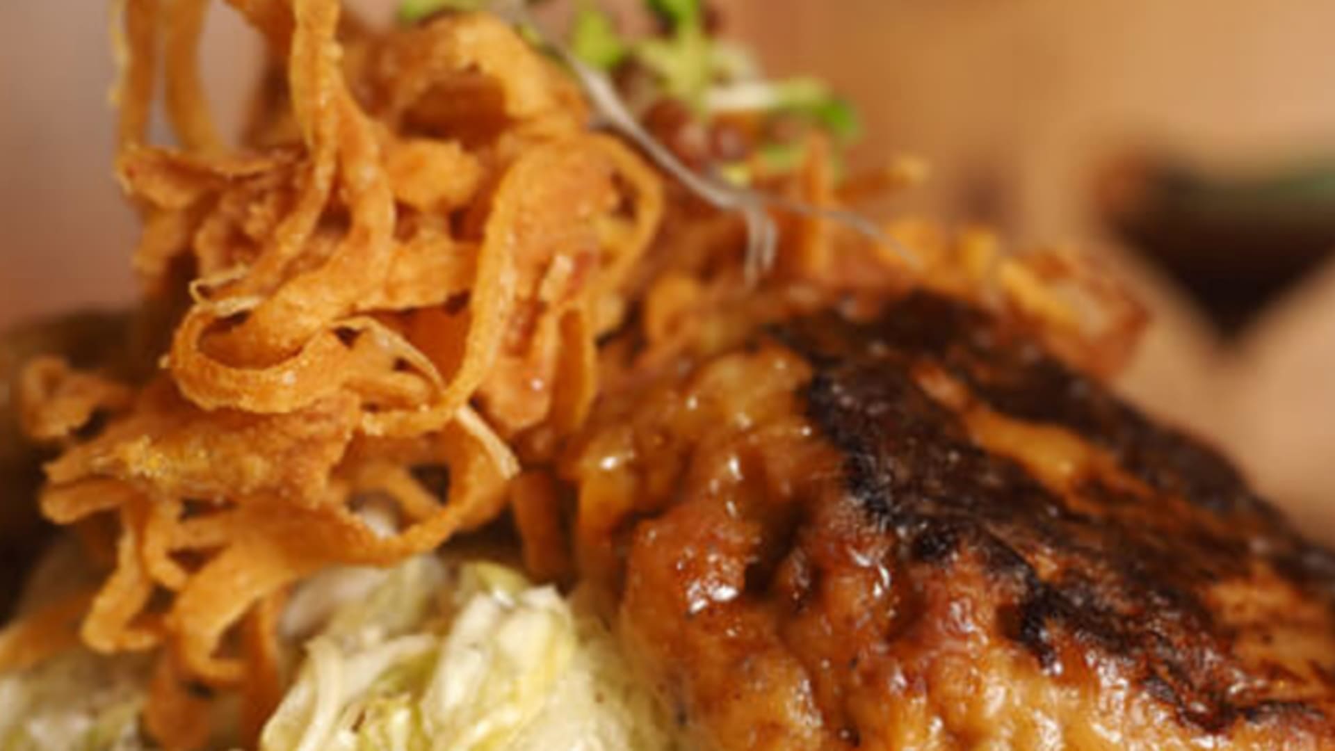 Gebratenes Fleischstück mit Kartoffelpüree und Zwiebelringen auf einem Teller in der Freiburger Hütte.