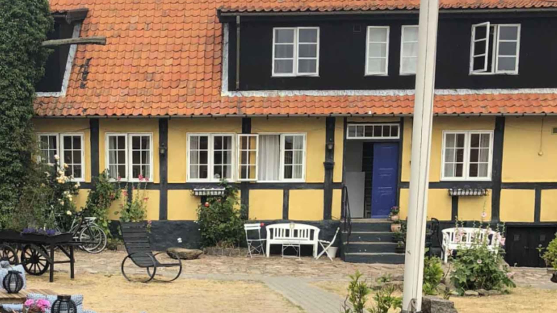 Fachwerkhaus der Pension Slaegtsgaarden mit gelben Wänden und gepflastertem Innenhof.