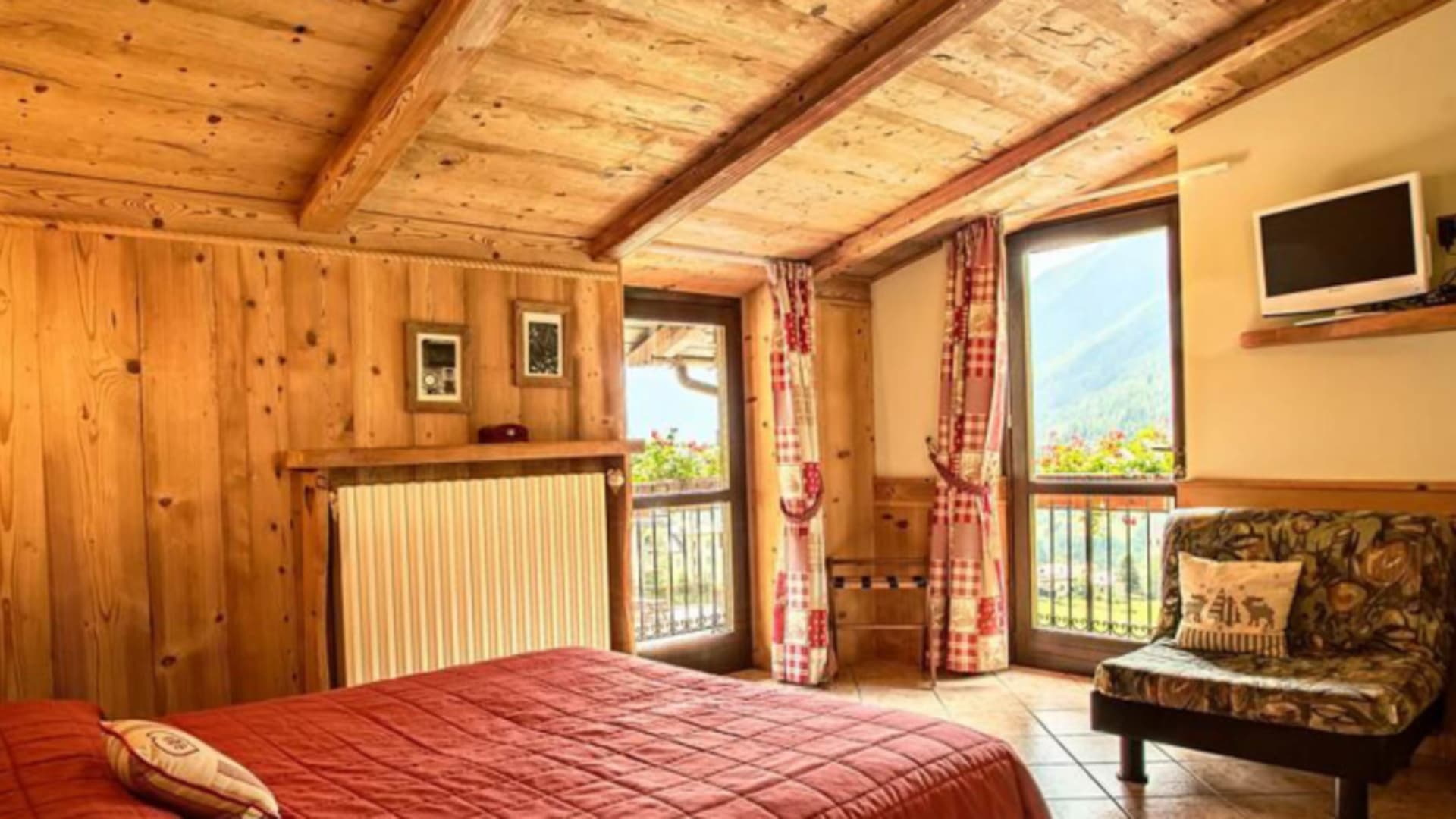 Gemütliches Doppelzimmer im Albergo della Pace mit Holzbalkendecke und Balkon mit Blick auf die Berghänge des Valle Stur