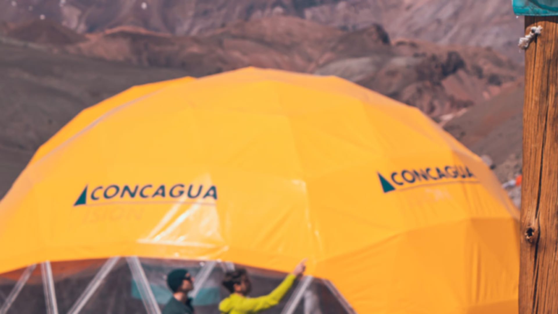 Gelbe und orange Expeditionszelte auf Plaza Argentina auf 4200 m mit schneebedeckten Bergketten im Hintergrund.