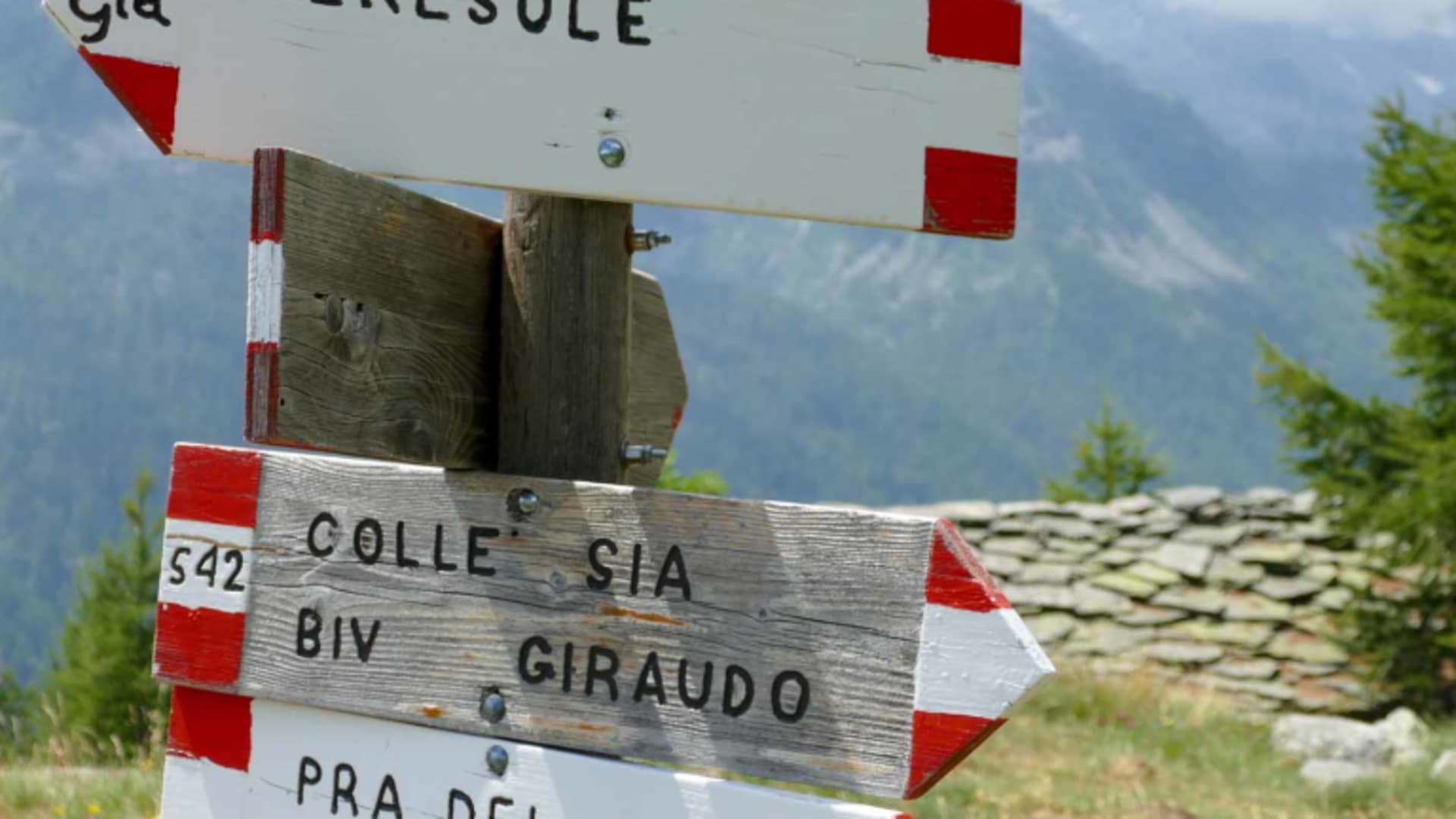 Bergwanderung auf der Grande Traversata delle Alpi: Wegweiser-Cluster am Holzpfahl mit GTA-Schild nach Ceresole, Colle Sia