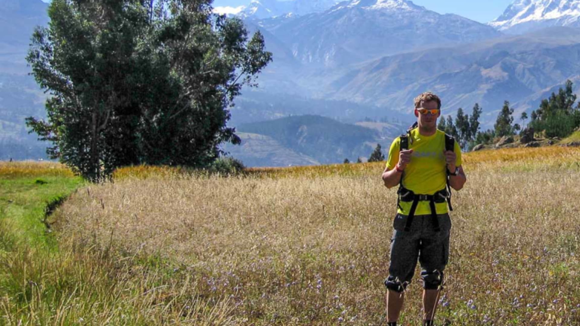 Höhenbergsteiger mit Wanderstöcken bei der Akklimatisation über Huaraz vor schneebedeckter Andenkette.