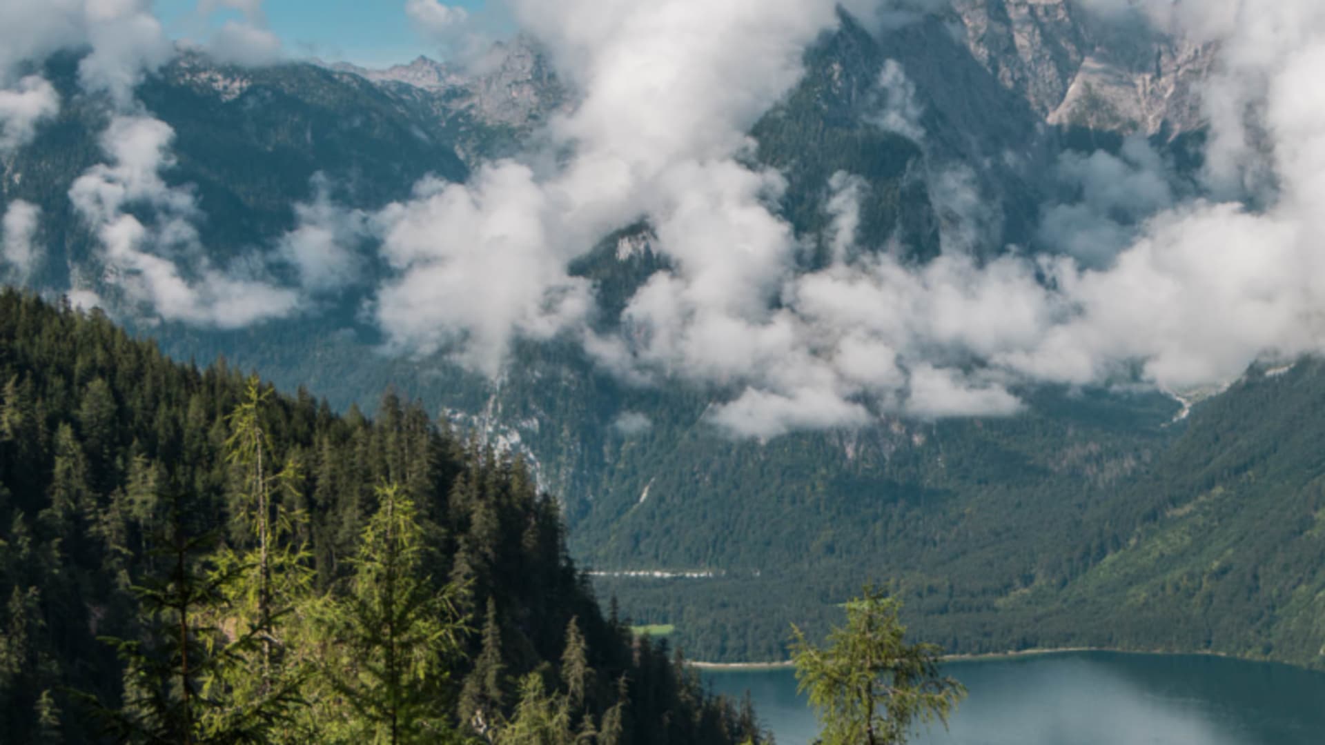 Panoramaaufnahme eines Bergsees zwischen bewaldeten Hängen mit felsigem Gipfel im Klettersteig-Gebiet Berchtesgaden nahe Grünstein