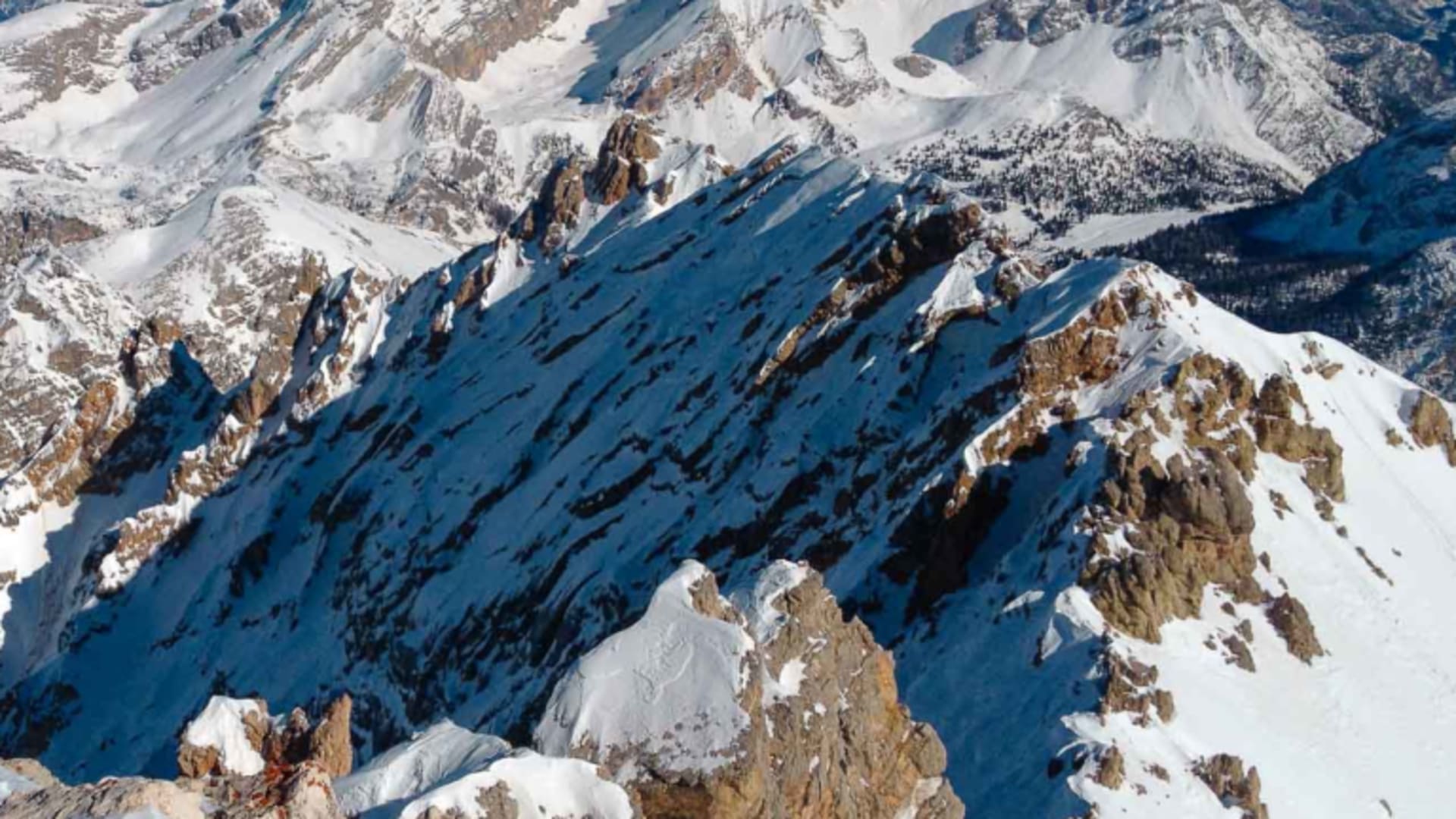 Skitour in den Dolomiten: Weitwinkel-Panorama auf verschneite Grate und Gipfel mit wolkenlosem Winterhimmel.