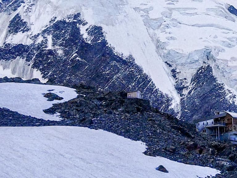 Das Refuge de Tête-Rousse steht auf einem Felshang zwischen Schneeflächen und Gletscherfeldern im Mont-Blanc-Massiv.