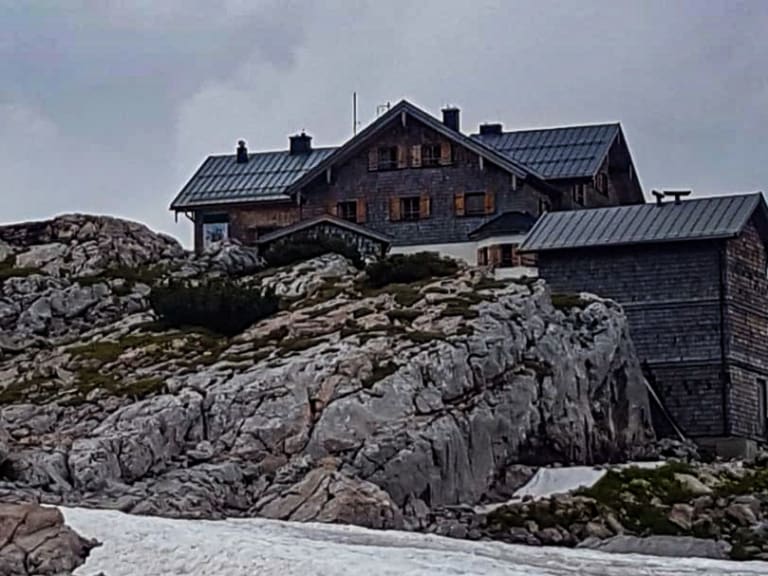 Das Ingolstädter Haus steht auf zerklüftetem Kalksteinfelsen mit Natursteinmauerwerk und Metalldach.