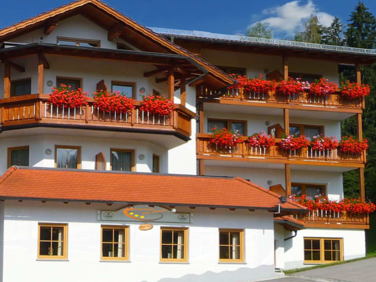 Außenansicht des Hotel-Garni zur Linde in Lohberg mit traditioneller Alpenfassade und Holzbalkonen.