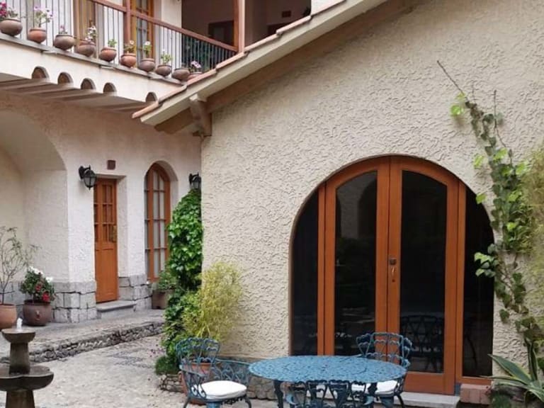 Gepflasterter Innenhof mit steinerner Brunnen im Hotel Rosario La Paz im Kolonialstil.