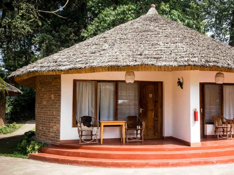 Rundbau mit Strohdach und überdachter Veranda in der Ilboru Safari Lodge bei Arusha.