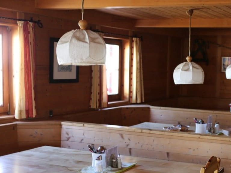 Traditioneller Gastraum der Oberwalder Hütte mit Holztischen und alpiner Einrichtung auf 2.973 m Höhe.