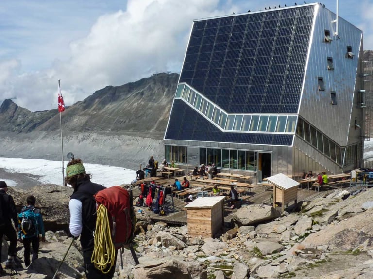 Bergsteiger mit Hochtouren-Ausrüstung vor der modernen Monte Rosa Hütte in den Walliser Alpen.