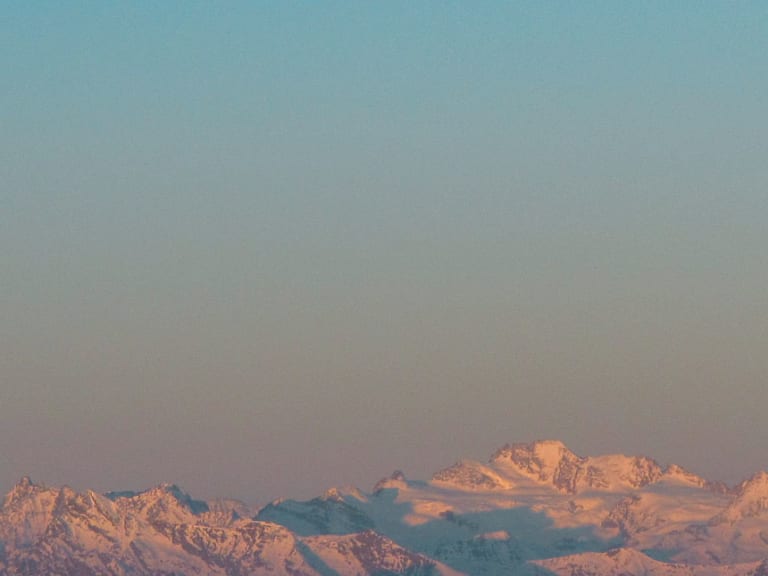Schneebedeckte Berggipfel mit Alpenglow und Vollmond während der Abenddämmerung beim Rifugio Città di Mantova.