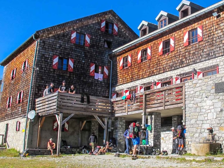 Bergsteiger versammeln sich vor der Kürsinger Hütte bei sonnigem Wetter vor ihrer Tour auf den Großvenediger.