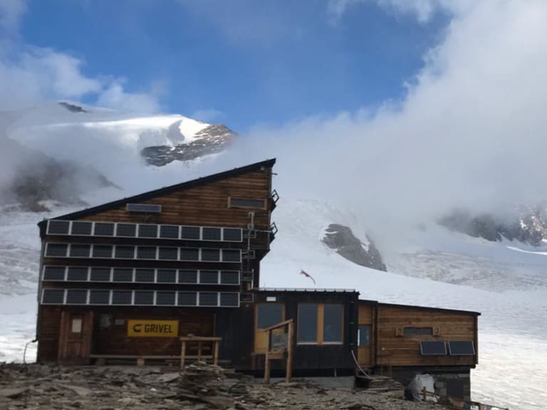 Seitenprofil des Rifugio Quintino Sella al Felik mit Solardach in schneebedeckter Gletscherlandschaft der Walliser Alpen