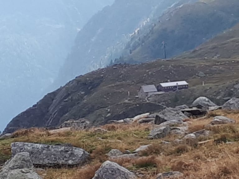 Panoramablick auf die Essener-Rostocker Hütte inmitten herbstlich gefärbter Almwiesen im Hochgebirge der Hohen Tauern.