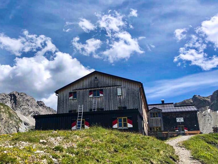 Die Memminger Hütte steht auf einer Anhöhe umgeben von schroffen Felswänden und Geröllhalden.