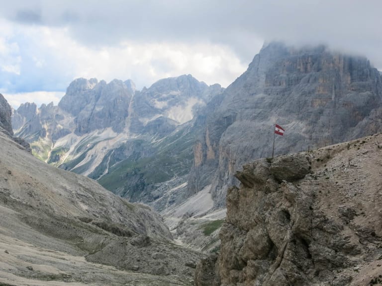 Blick von der Grasleitenpasshütte ins Vajolet-Tal mit steilen Dolomitfelswänden und schuttbedecktem Hang im Vordergrund.
