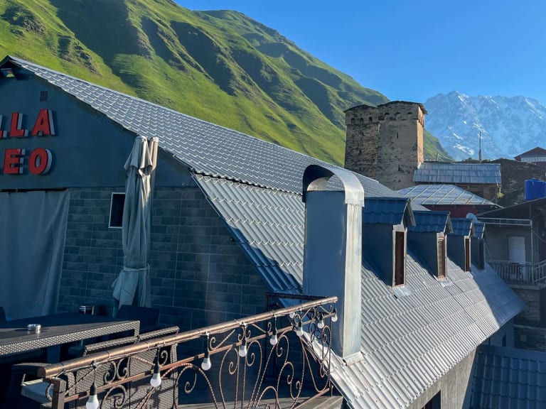 Außenansicht der Villa Lileo mit charakteristischem blauen Gebäude und historischem Steinturm in Ushguli, Swanetien.