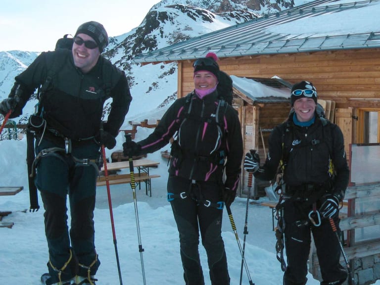 Drei Skitourengeher stehen vor der Martellerhütte auf 2.585 m im verschneiten Ortlergebiet bei klarem Winterwetter.