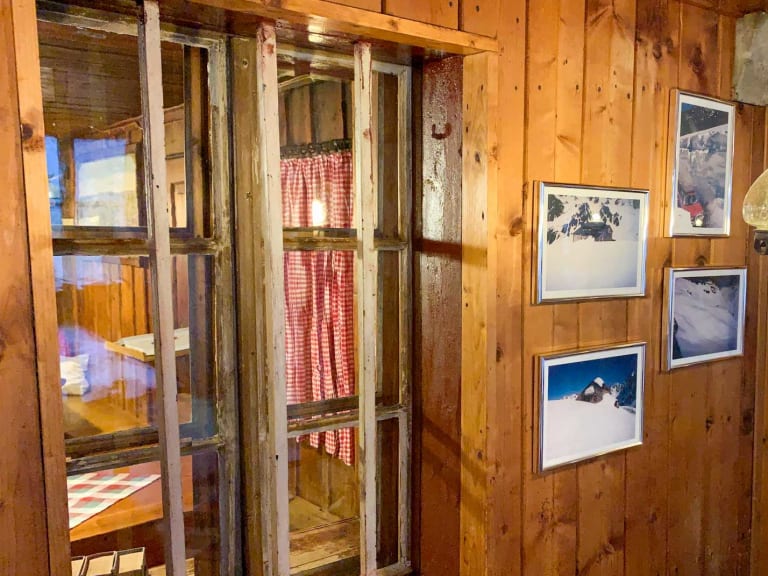 Der gemütliche Gastraum der Darmstädter Hütte zeigt traditionelle Holzvertäfelung und alpine Wanddekoration.