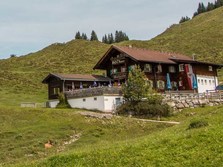 Panoramablick über die Walleralm mit Berghütten auf grünen Almwiesen im Kaisergebirge.