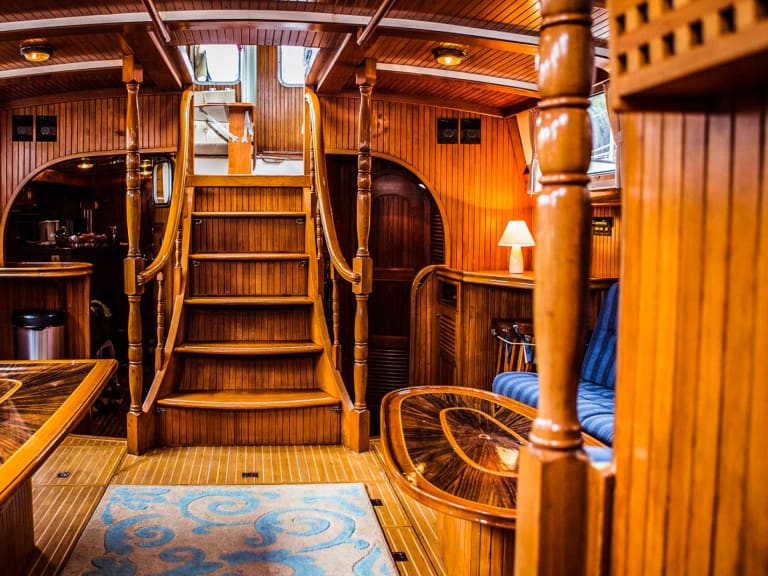 Der Salon der Ylva zeigt eine breite Holztreppe mit gedrechselten Geländern und einen Navigationsbereich mit nautischen Instrumenten.