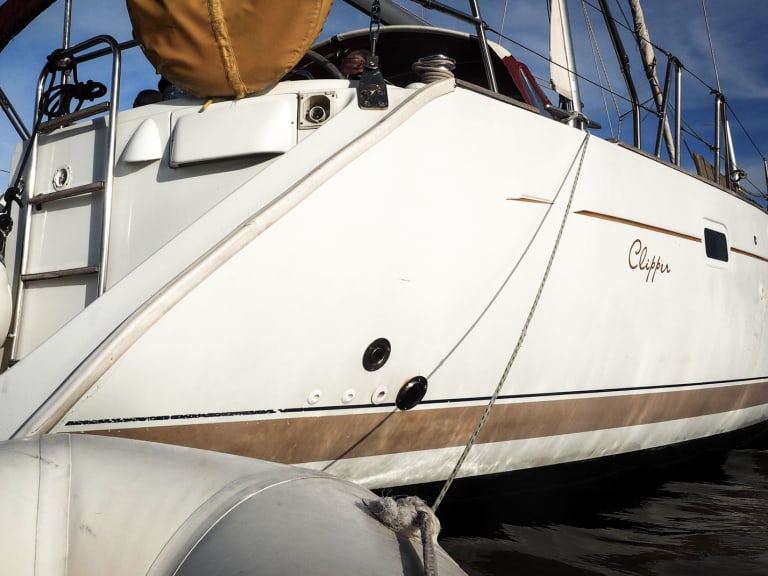 Die griechische Yacht Clipper liegt vor der felsigen Küste von Kalymnos, fotografiert vom Schlauchboot aus.