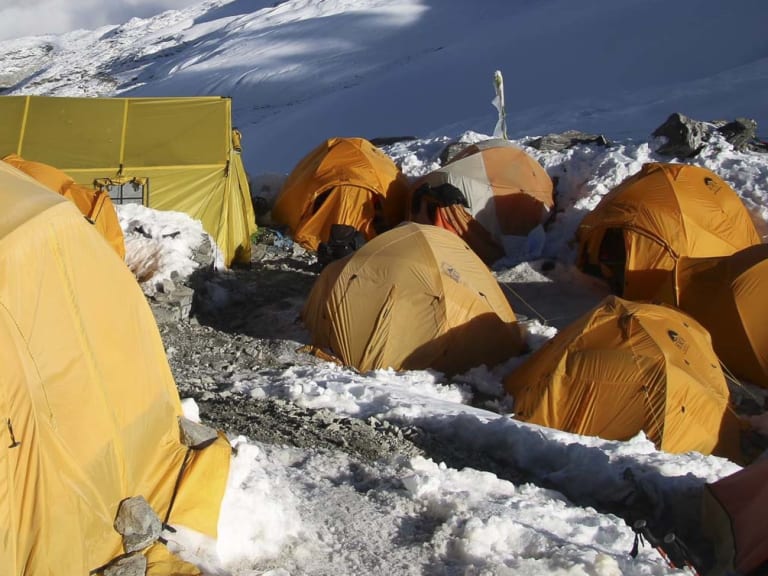 Hochlager Mera Peak mit gelben und orangen Expeditionszelten auf schneebedecktem Plateau in der Barun-Region.