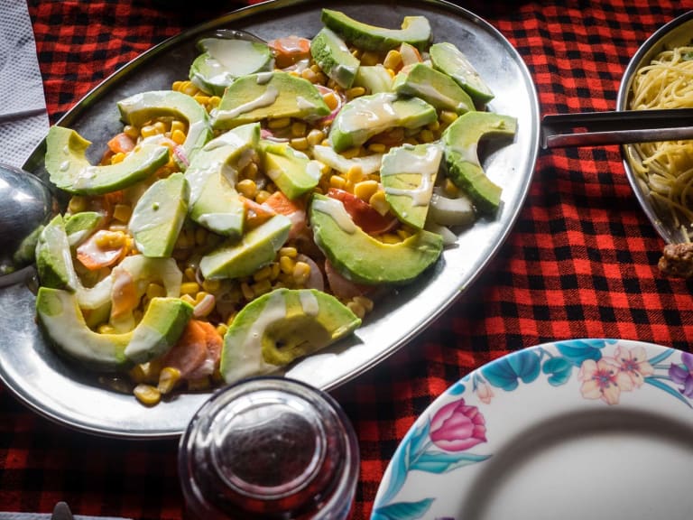 Frisch zubereitete Mahlzeit mit buntem Salat und warmen Gerichten im Zeltcamp am Mount Kenia.