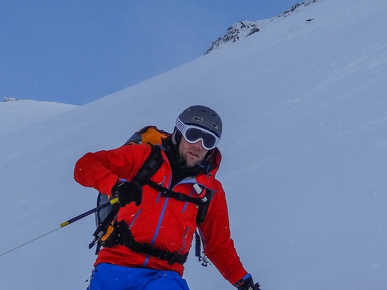 Bei einer Skitour fährt Bergführer Andreas Wiedenmann durch unberührten Tiefschnee einen steilen Hang hinab.