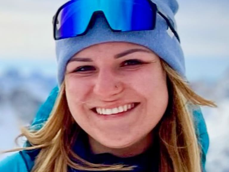 Portrait von Bergwanderführerin Alina Elisabeth Leitinger mit grauer Mütze und türkiser Softshelljacke.