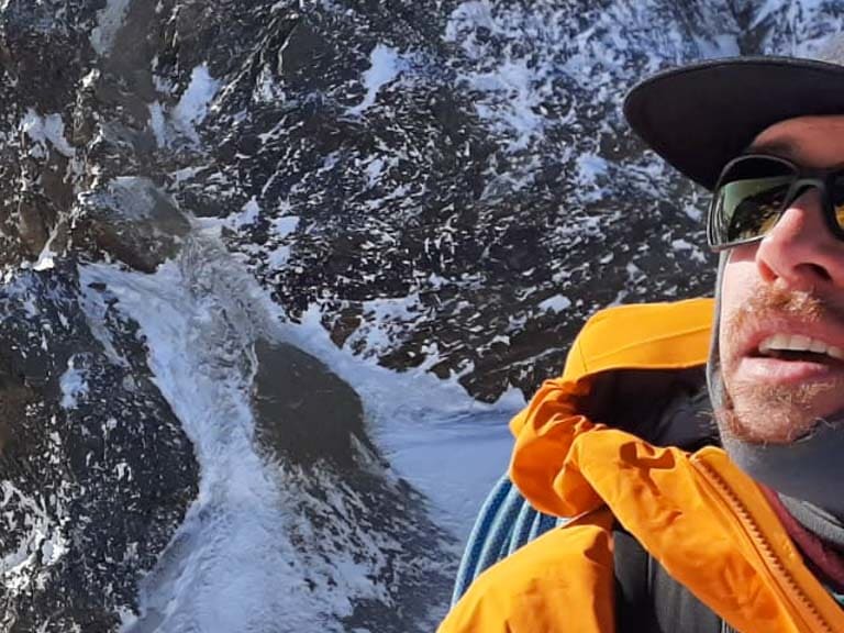 Drei Bergsteiger steigen durch verschneites Hochgebirge auf, Bergwanderführer Timo Reichert führt die Gruppe.