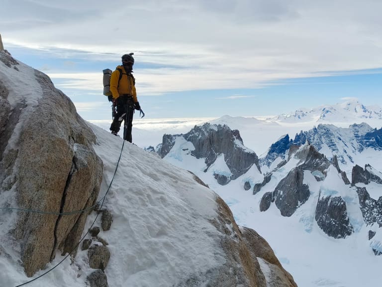 Mit Pickel und blauem Seil steht Bergführer Alexander Berger auf steilem, verschneitem Hang im Hochgebirge.