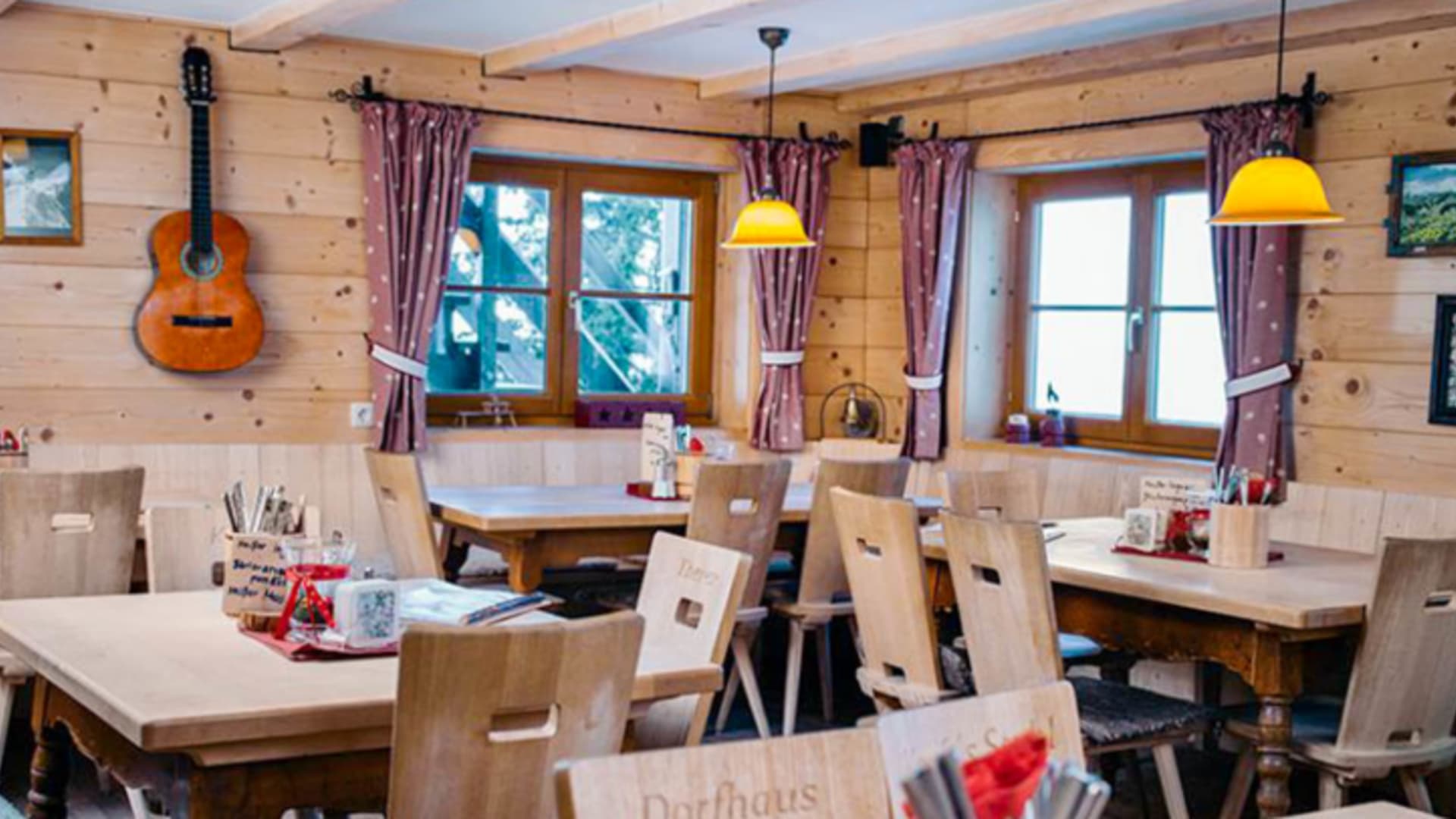 Traditionelle Gaststube im Staufner Haus zeigt Holztische und alpine Wanddekoration in gemütlicher Berghüttenatmosphäre.