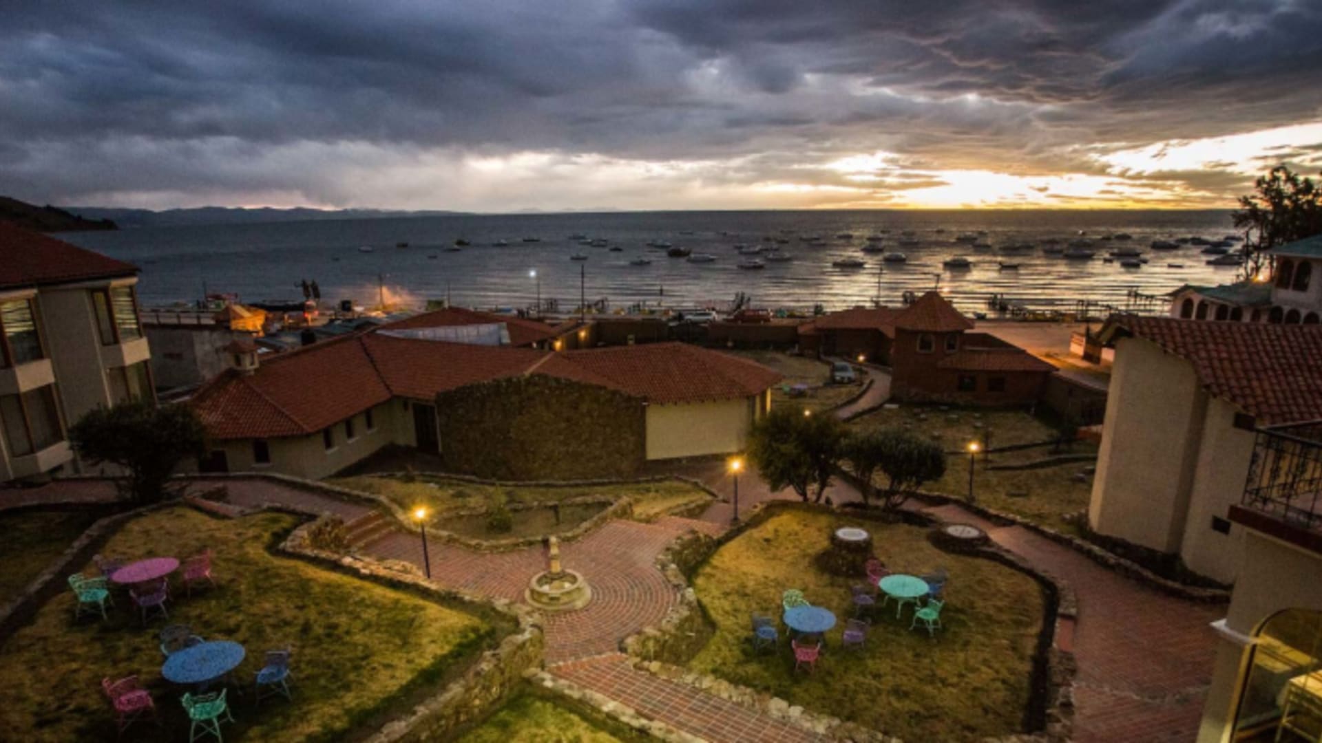 Luftbild des Hotel Rosario Lago Titicaca bei Abenddämmerung mit kreisförmigem Innenhof und Blick über den Titicacasee.