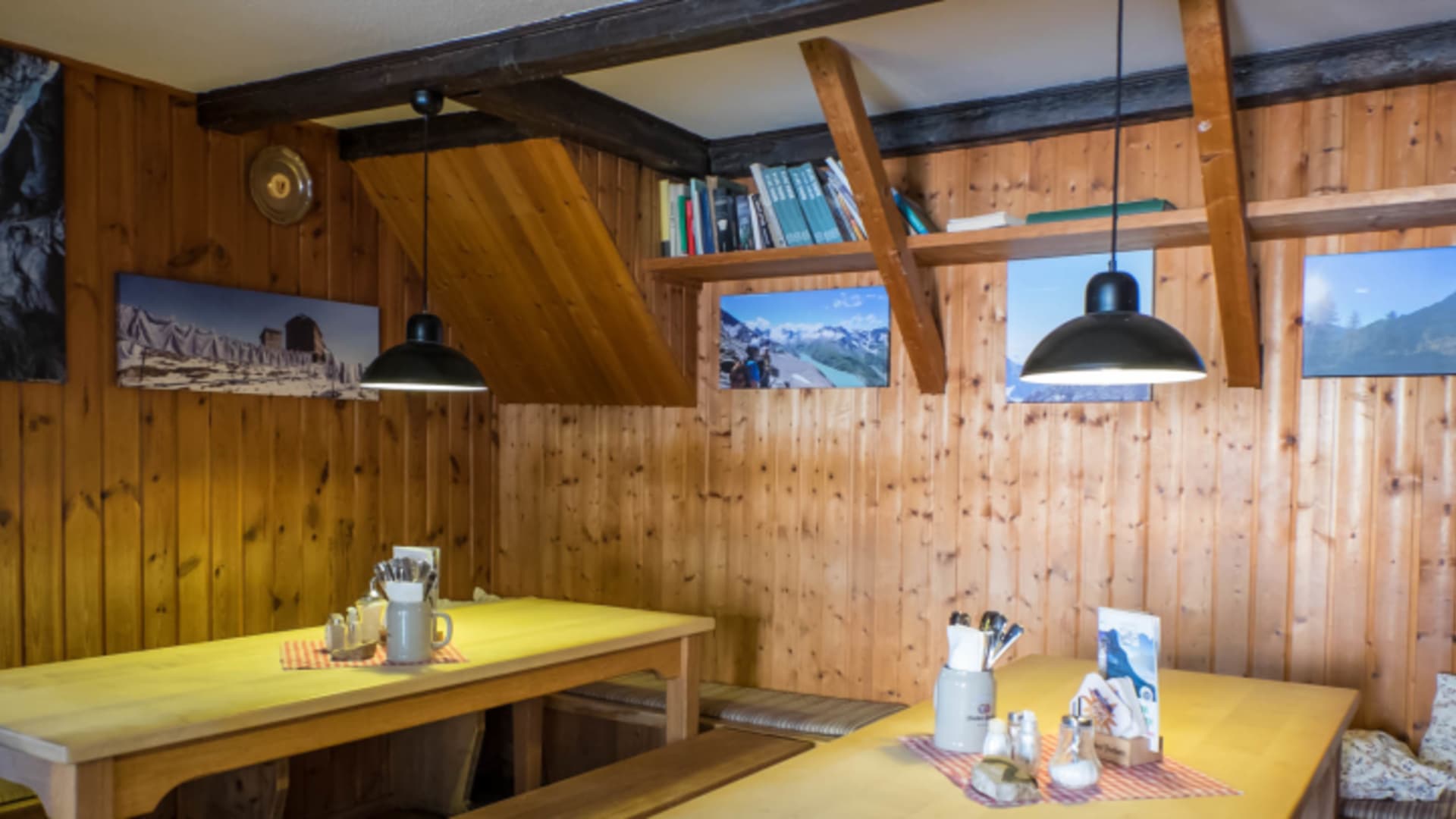 Gemütliche Gaststube der Knorrhütte mit Holztischen, Bergfotos und traditioneller Alpenausstattung.
