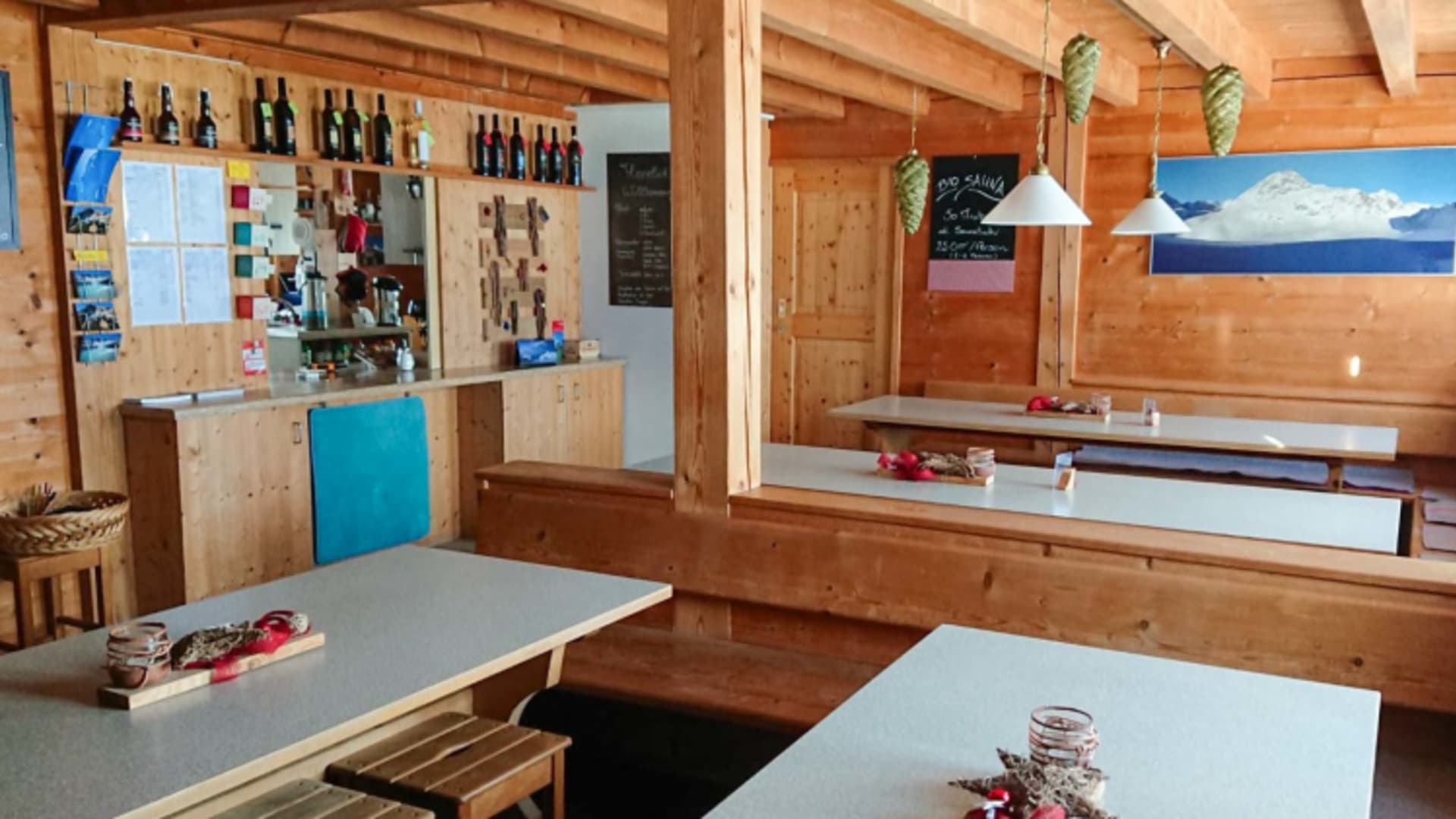 Traditionelle Gaststube der Chamanna Jenatsch mit Holzvertäfelung, Tischen und gemütlicher Hüttenatmosphäre.