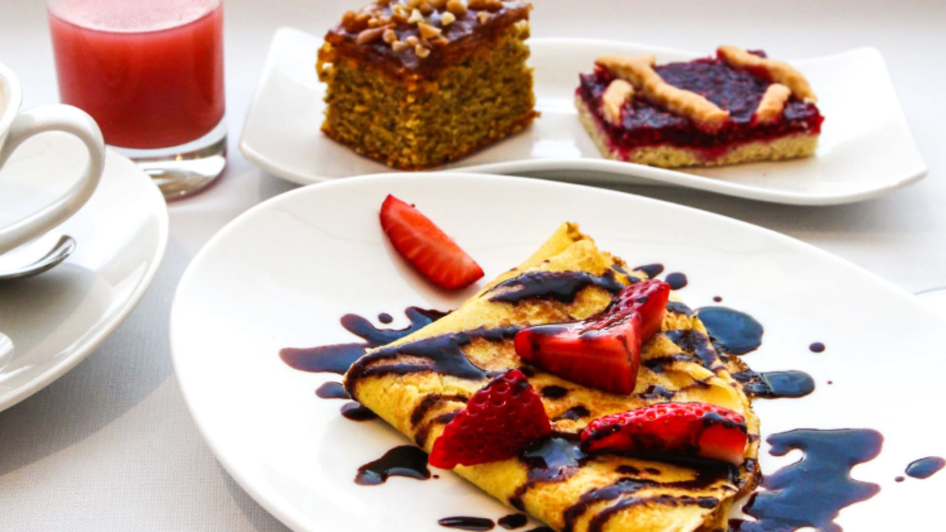 Dessert-Arrangement mit Pfannkuchen und Erdbeeren auf weißem Teller im City Hotel Meran Restaurant.