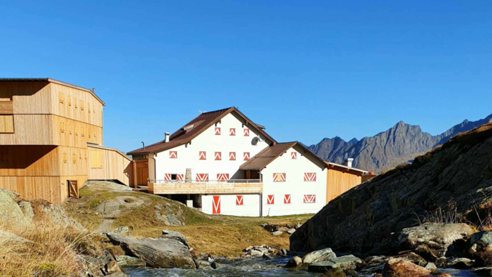 Bergbach fließt vor der Neuen Regensburger Hütte durch herbstliche Almlandschaft vorbei.