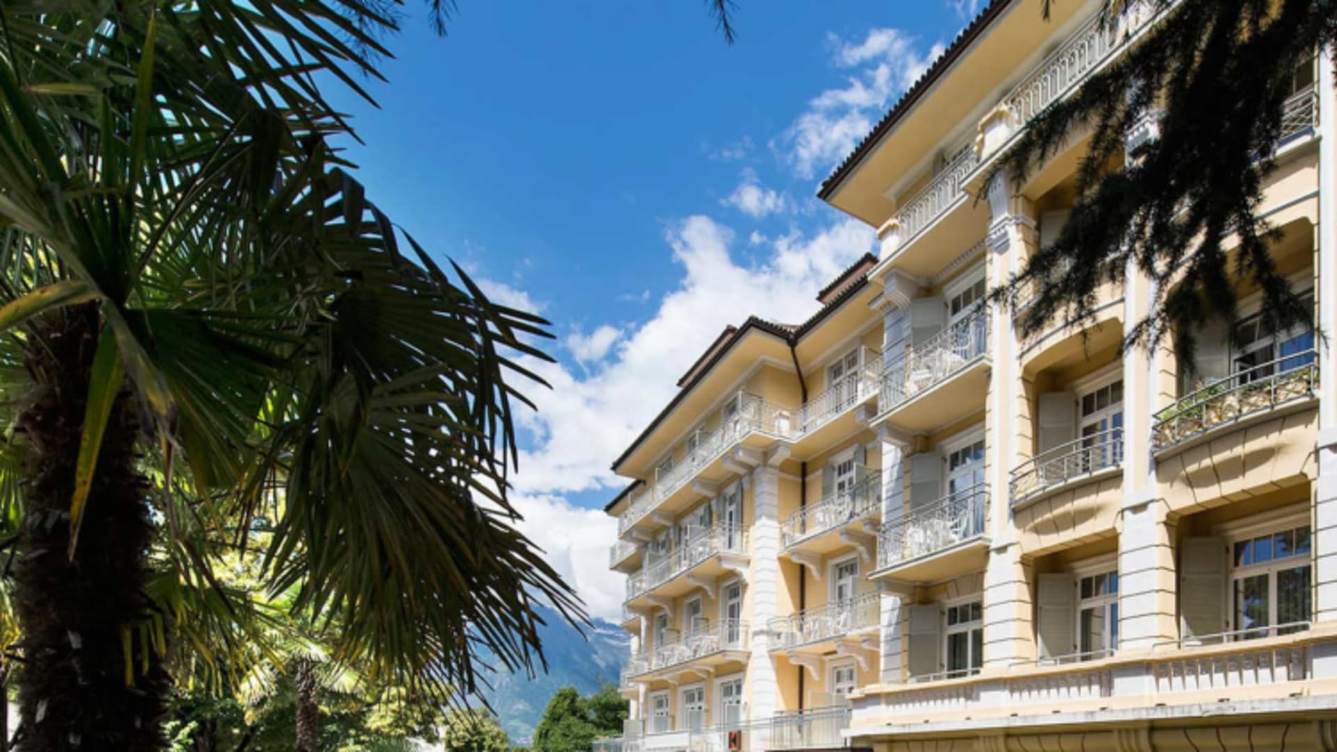 Außenansicht vom Hotel Kolping Meran mit klassischer Jugendstilfassade und Säulen im Erdgeschoss.