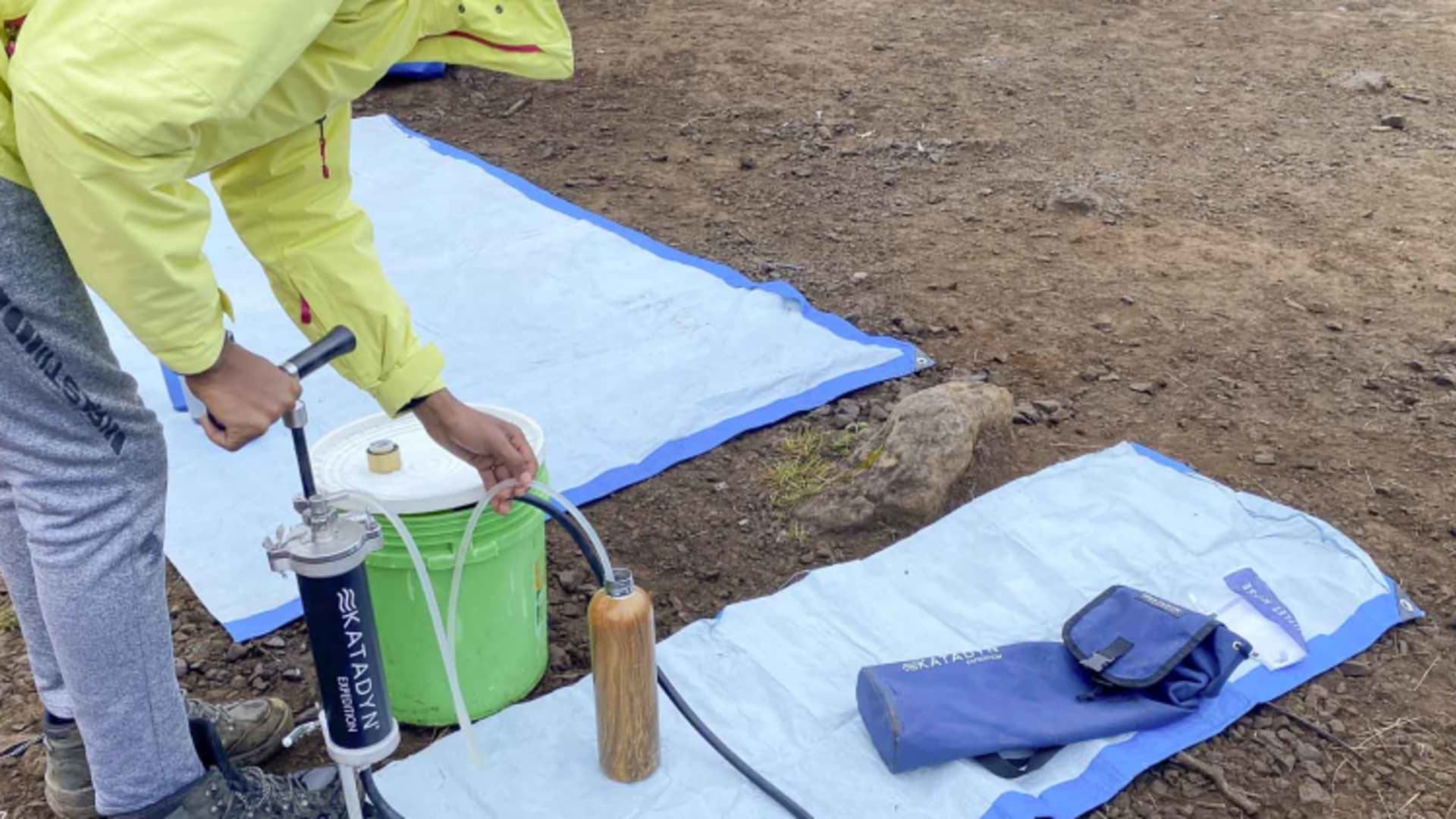 Bergsteiger bedient Katadyn-Wasserfilter zur Trinkwasseraufbereitung im Zeltcamp am Kilimanjaro während einer Expedition.