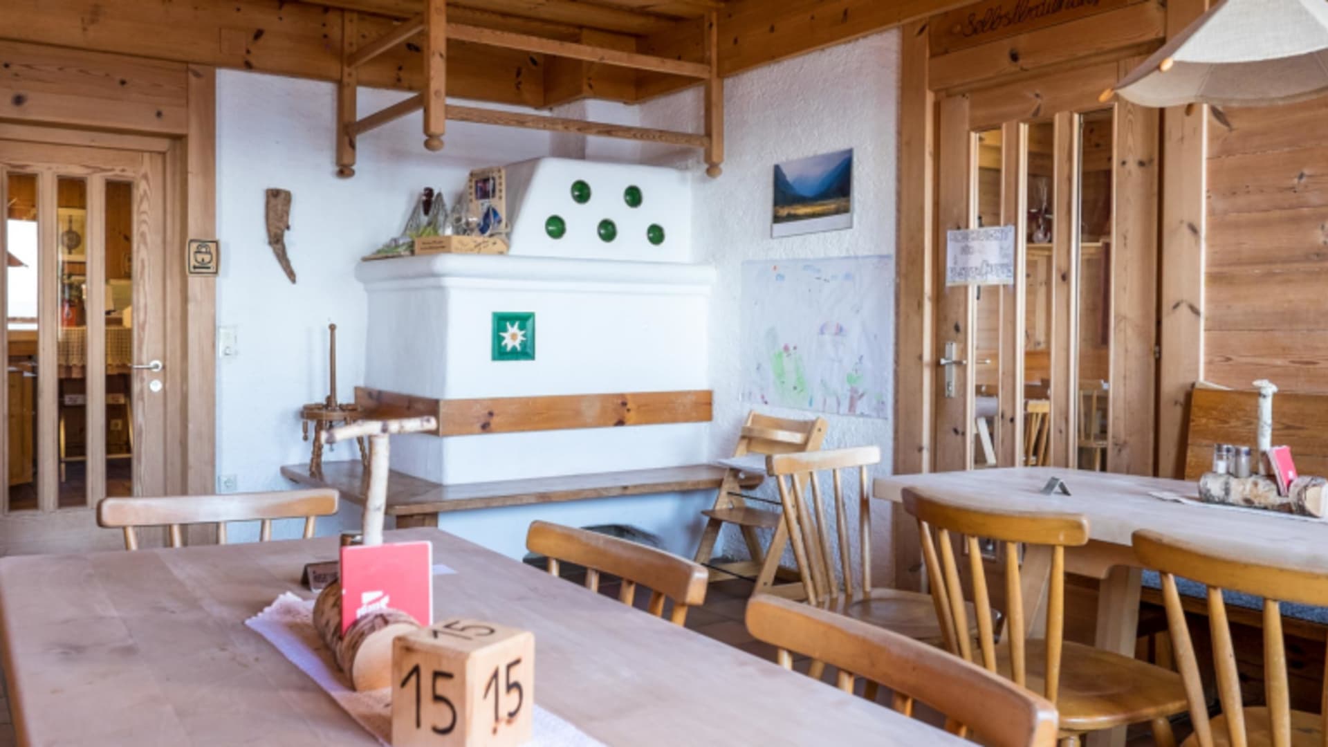 Traditioneller Gastraum der Hofpürglhütte mit Holztischen, Holzstühlen und rustikaler Almhütten-Einrichtung.