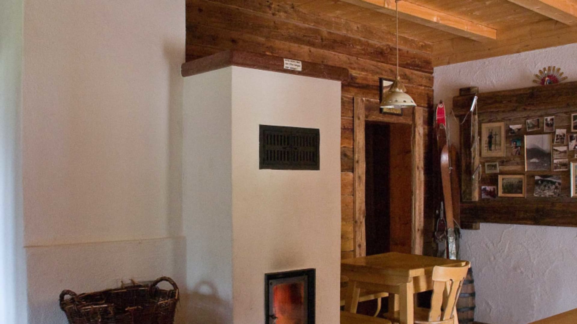 Gemütlicher Gastraum der Kührointhütte mit weißem Kachelofen und traditioneller Holzausstattung.