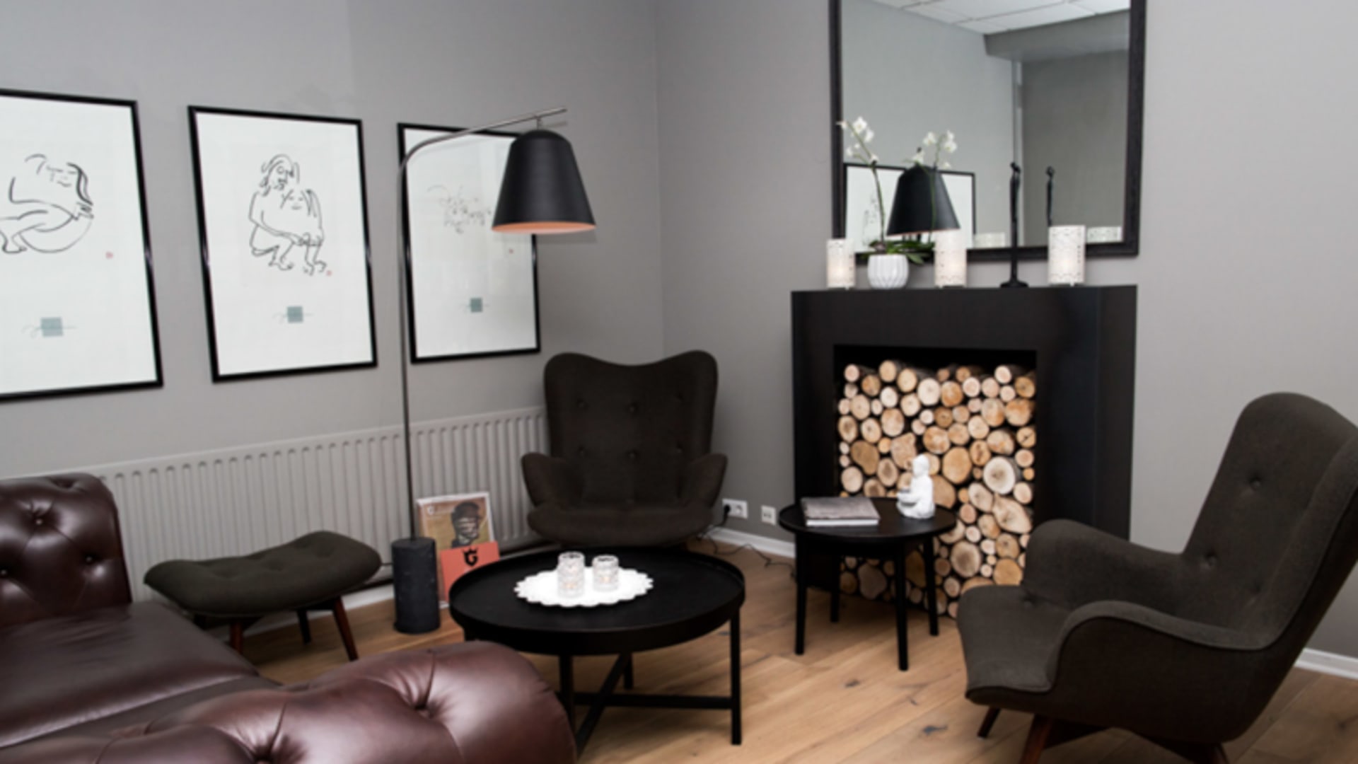 Gemütlicher Lounge-Bereich mit Kamin und Ledersesseln im 22 Hill Hotel Reykjavík mit skandinavischem Design.