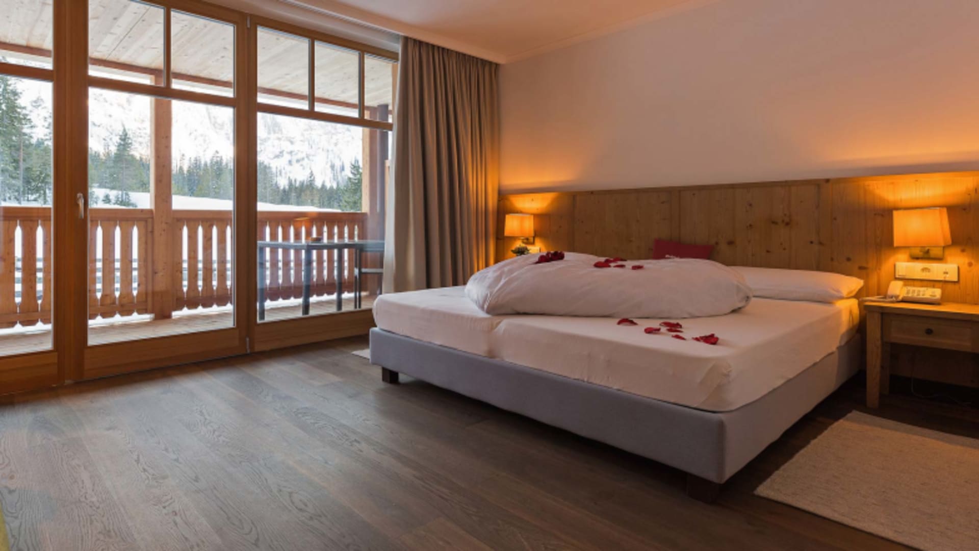 Alpines Doppelzimmer im Gasthof Brückele Ausserprags mit Balkon und Bergblick auf verschneite Dolomitengipfel.