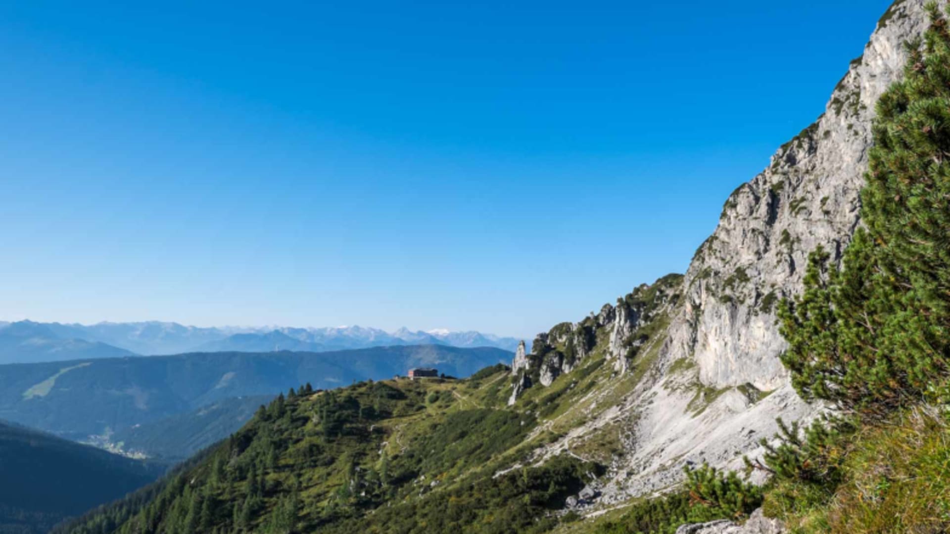 Bergpanorama vom Standort der Hofpürglhütte mit Blick über bewaldete Täler und Kalksteinwände.