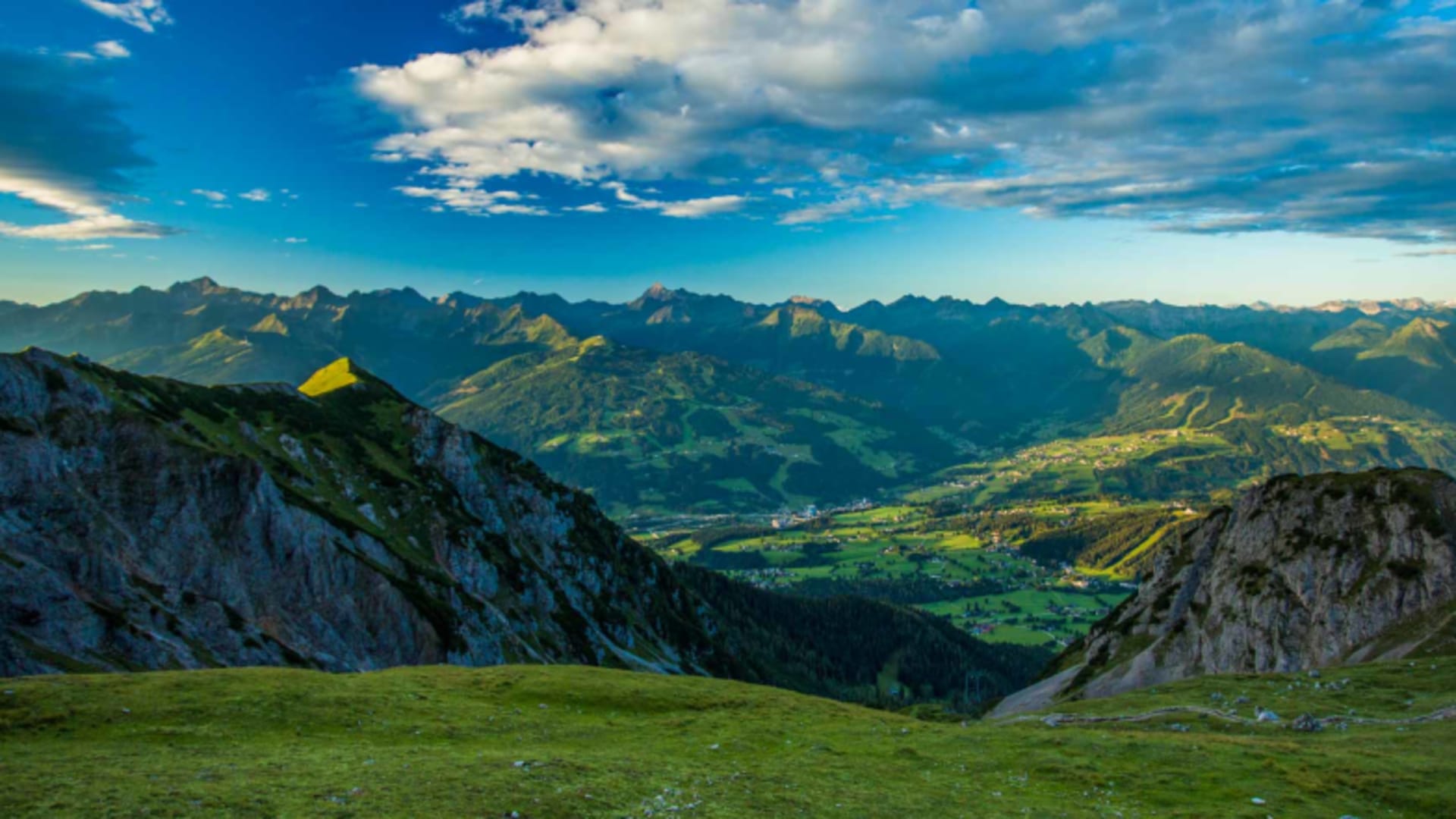 Panoramablick vom Guttenberghaus-Plateau ins Tal mit gelben Zelt und weiter Berglandschaft.