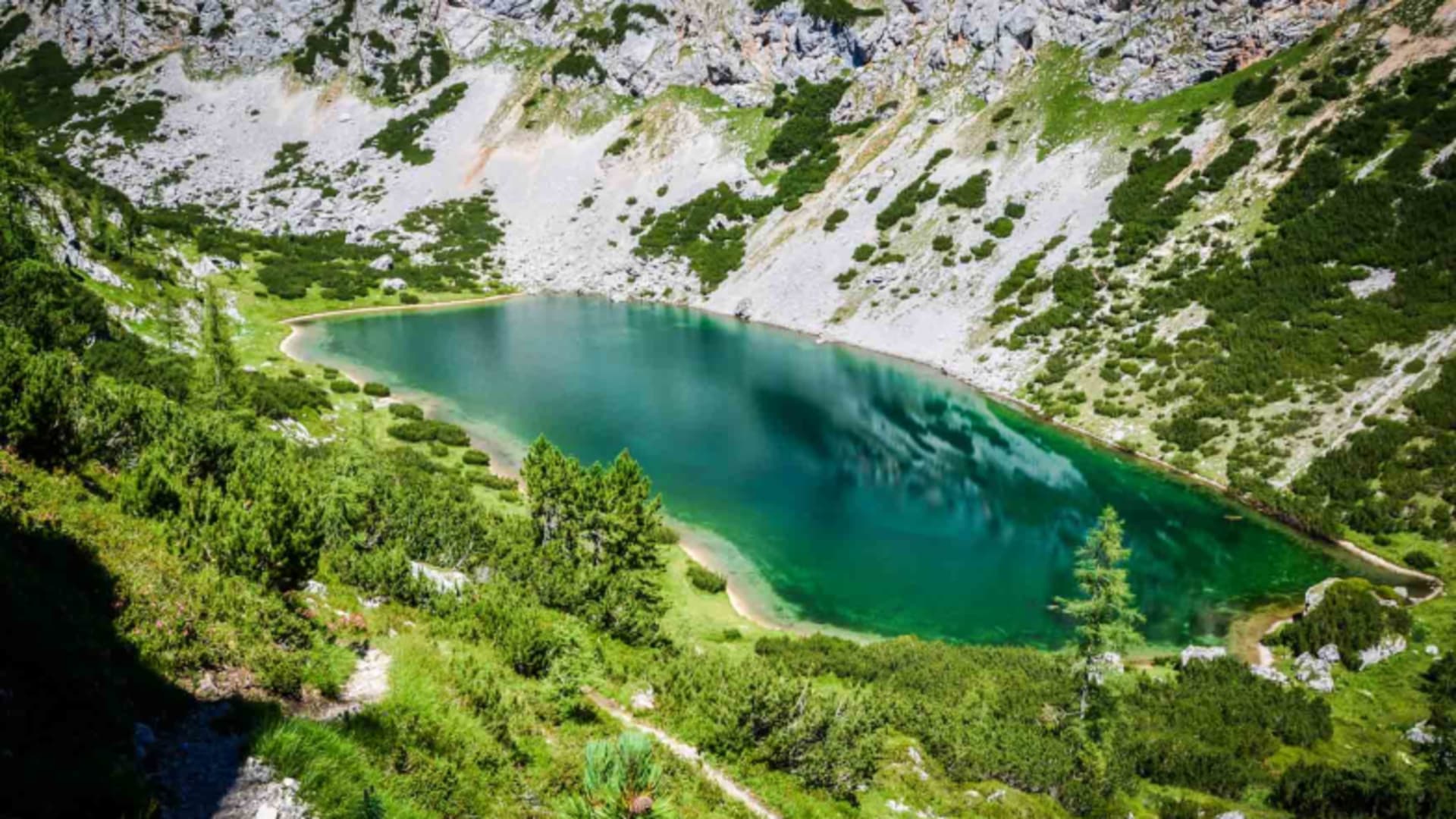 Türkisfarbener Bergsee in Felszirkus mit Wanderweg vom Guttenberghaus im Dachsteinmassiv.