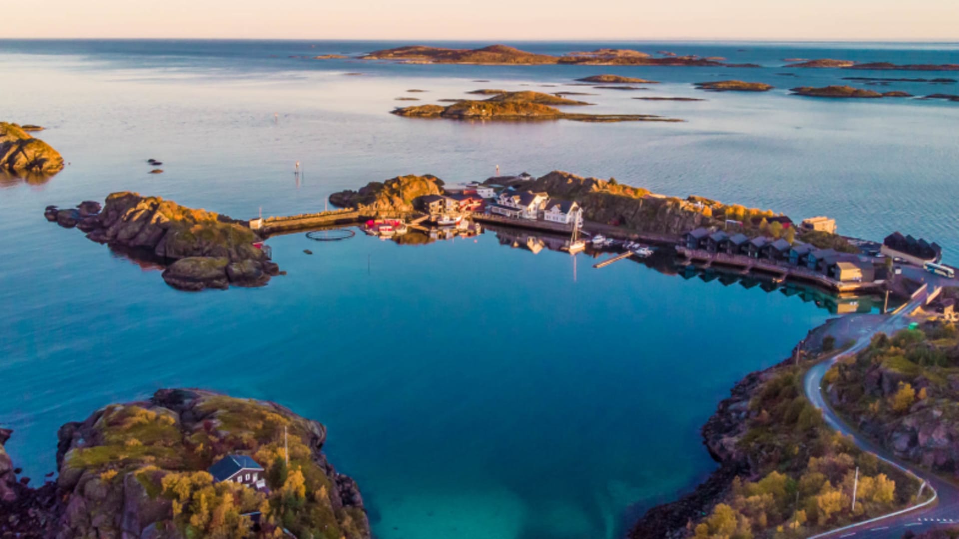 Luftbild der geschützten Bucht mit Hamn i Senja Anlage umgeben von herbstlicher Vegetation.